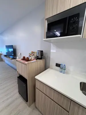 a kitchen with a white counter and a microwave at BubbleHumbleBangkok in Bangkok