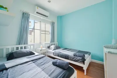 two beds in a room with blue walls at Modern 3BR Rama Mansion Near Airport plus Amenities in Sathani Ban Hua Mak
