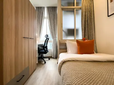 a bedroom with a bed and a desk and a window at 150m to BTS l Workspace l Pool and Gym l Sontana in Bangkok