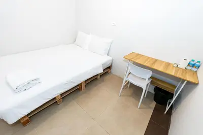 a small bedroom with a bed and a desk at The Hidden Khaosan Bangkok in Bang Bua Thong Railway Station