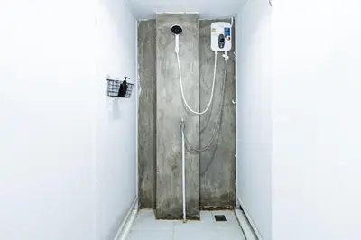 a shower stall in a bathroom with a shower at The Hidden Khaosan Bangkok in Bang Bua Thong Railway Station