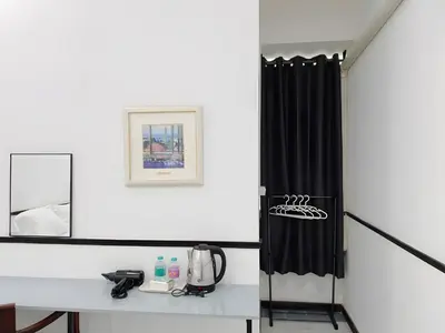 a bathroom with a black shower curtain and a table at XX GO INN MRT Hua Lamphong - วัดไตรมิตร in Samphanthawong