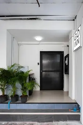 a black door in a room with potted plants at XX GO INN MRT Hua Lamphong - วัดไตรมิตร in Samphanthawong