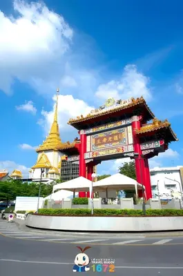 a large red structure with a pagoda in the background at XX GO INN MRT Hua Lamphong - วัดไตรมิตร in Samphanthawong
