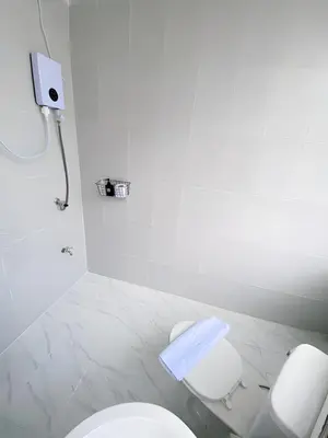 a white bathroom with a toilet and a shower at XX GO INN MRT Hua Lamphong - วัดไตรมิตร in Samphanthawong
