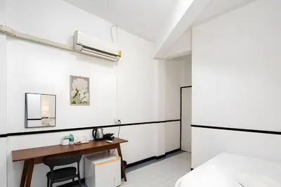 a bedroom with a desk and a bed at XX GO INN MRT Hua Lamphong - วัดไตรมิตร in Samphanthawong