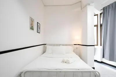 a white bed in a room with two towels on it at XX GO INN MRT Hua Lamphong - วัดไตรมิตร in Samphanthawong