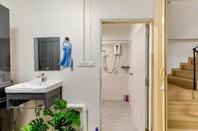a small bathroom with a sink and a staircase at Cozy 5-story house, 2 mins walk BTS, BKK in Bangkok