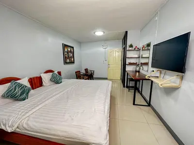 a bedroom with a bed and a desk and a television at Nuanchan Apartment in Ban O Pao