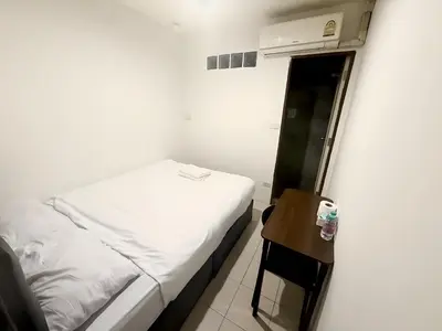 a small bedroom with a bed and a small table at xxzNAP - Khaosan Road สแนป ตรอกข้าวสาร in Bang Bua Thong Railway Station