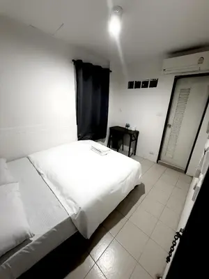 a large white bed in a room with a table at xx zNAP - Khaosan Bangkok แนป ข้าวสาร กลางตรอกข้าวสาร in Bang Bua Thong Railway Station