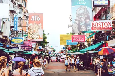 a busy city street with people walking down the street at xx zNAP - Khaosan Bangkok แนป ข้าวสาร กลางตรอกข้าวสาร in Bang Bua Thong Railway Station