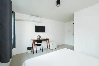 a bedroom with a bed and a table and a television at SleepPop Sukhumvit 42 - BTS Ekkamai in Phra Khanong
