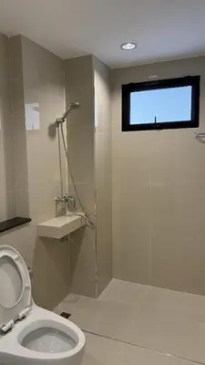 a bathroom with a toilet and a glass shower at Nene Apartment in Ban Bang Talat