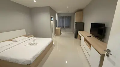 a bedroom with a bed and a flat screen tv at Nene Apartment in Ban Bang Talat