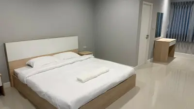 a bedroom with a large bed with white sheets and pillows at Nene Apartment in Ban Bang Talat