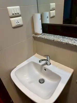 a white sink in a bathroom with a mirror at MrchowRoom in Bangkok