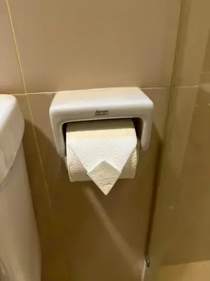 a toilet paper dispenser on a wall in a bathroom at MrchowRoom in Bangkok