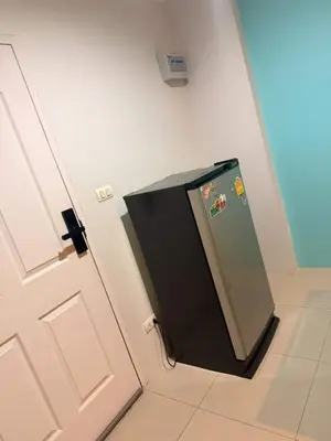 a small refrigerator in a room next to a door at อุดมสุข BTS udomsuk in Bangna