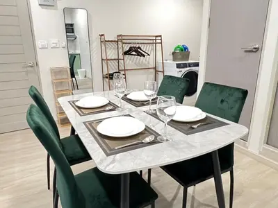 a dining room table with plates and wine glasses at New Apt, Near Siam Paragon, 2 Min to BTS 1BR,4Pax in Bangkok