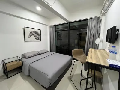 a bedroom with a bed and a desk with a computer at Hug14 Hotel in Ban Bang Toei (1)