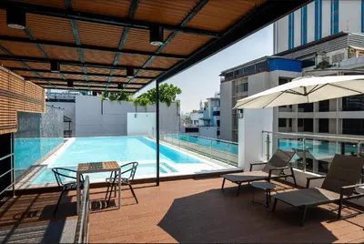 a patio with a table and chairs and a swimming pool at 6th Avenue Sukhumvit BKK 409 BTS Asoke Nana MRT Sukhumvit in Bangkok