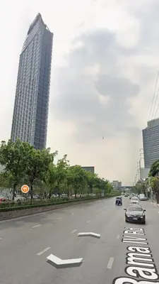 a street with cars driving down a street with tall buildings at Luxury duplex condominium Samyan area 28th fl near MRT in Bangkok