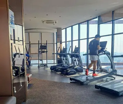 a man standing on a treadmill in a gym at Luxury duplex condominium Samyan area 28th fl near MRT in Bangkok