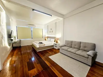 a living room with a couch and a bed at W House in Phra Khanong