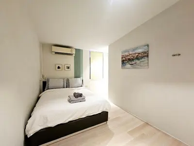 a bedroom with a bed in a white room at W House in Phra Khanong