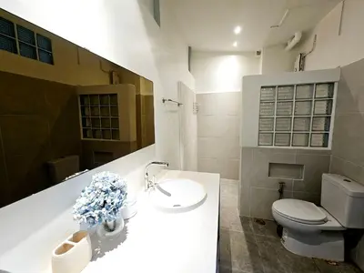 a bathroom with a white sink and a toilet at W House in Phra Khanong