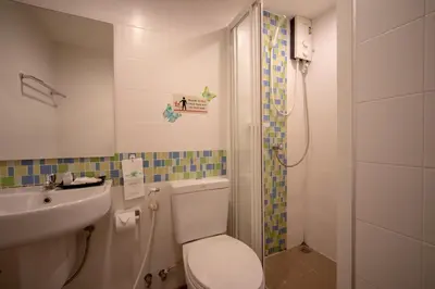 a bathroom with a toilet and a sink and a shower at Taradii Boutique in Bangkok