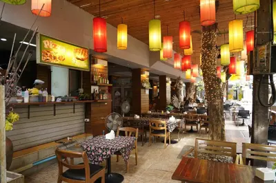 a restaurant with tables and chairs and chinese lights at Taradii Boutique in Bangkok