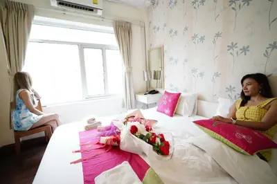 a woman sitting on a bed with a baby on it at Taradii Boutique in Bangkok