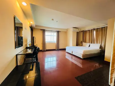 a bedroom with a bed and a television in a room at NSC Apartel in Bangkok