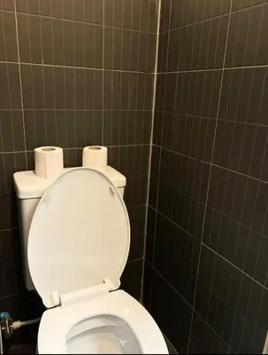 a bathroom with a toilet with two rolls of toilet paper at Bongo Residence Ratchathewi Bangkok in Bangkok