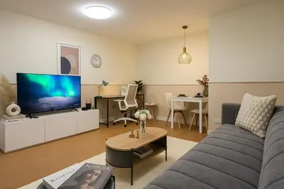 a living room with a couch and a flat screen tv at Cozy Designer Apartment - Sukhumvit 39 in Bangkok