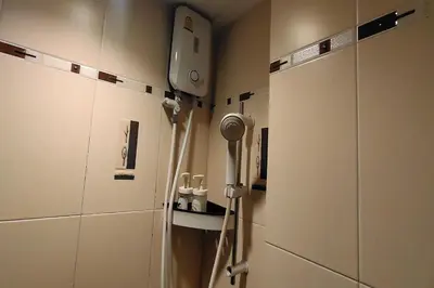 a bathroom with a hair dryer on the wall at Pratunam Family House in Ban Nong Chaeng