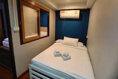 a small bed in a small room with a mirror at Pratunam Family House in Ban Nong Chaeng