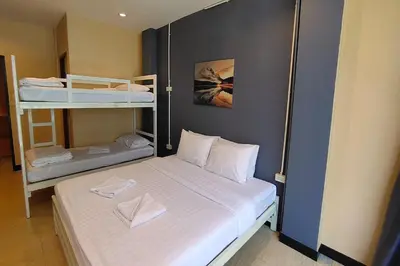 a small room with a bed and bunk beds at Pratunam Family House in Ban Nong Chaeng