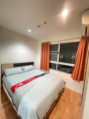 a bedroom with a bed with orange curtains and a window at Lumpini nawamin in Ban Bang Toei (1)