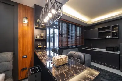 a kitchen with a counter with chairs and a table at Delta 9 Phrakanong in Bangkok