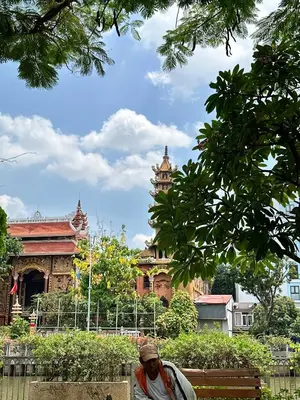 a man sitting on a bench in front of a building at Super BIG Mid Century Home near River & IconSiam in Khlong San