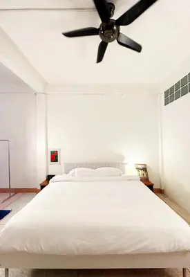 a bedroom with a white bed with a ceiling fan at Super BIG Mid Century Home near River & IconSiam in Khlong San