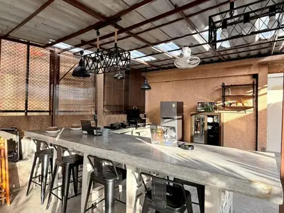 a large kitchen with a large counter with bar stools at Super BIG Mid Century Home near River & IconSiam in Khlong San