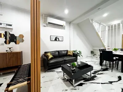 a living room with a black leather couch and a table at Number 31 Bangkok Family in Bangkok