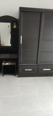 a bathroom with a black dresser and a mirror at Sathitsit Mansion in Bangkok