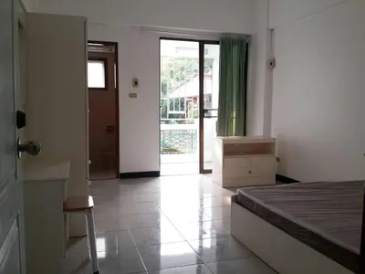 a bedroom with a bed and a sliding glass door at Sathitsit Mansion in Bangkok