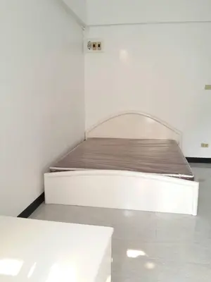 a white bed in a white room with at Sathitsit Mansion in Bangkok