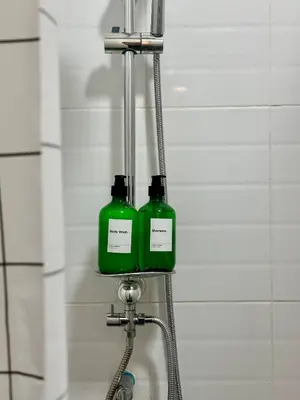 two green bottles on a rack in a bathroom at Walk2BTS, KingBed, FastWiFi, FreeLaundry, Netflix in Khlong Toei